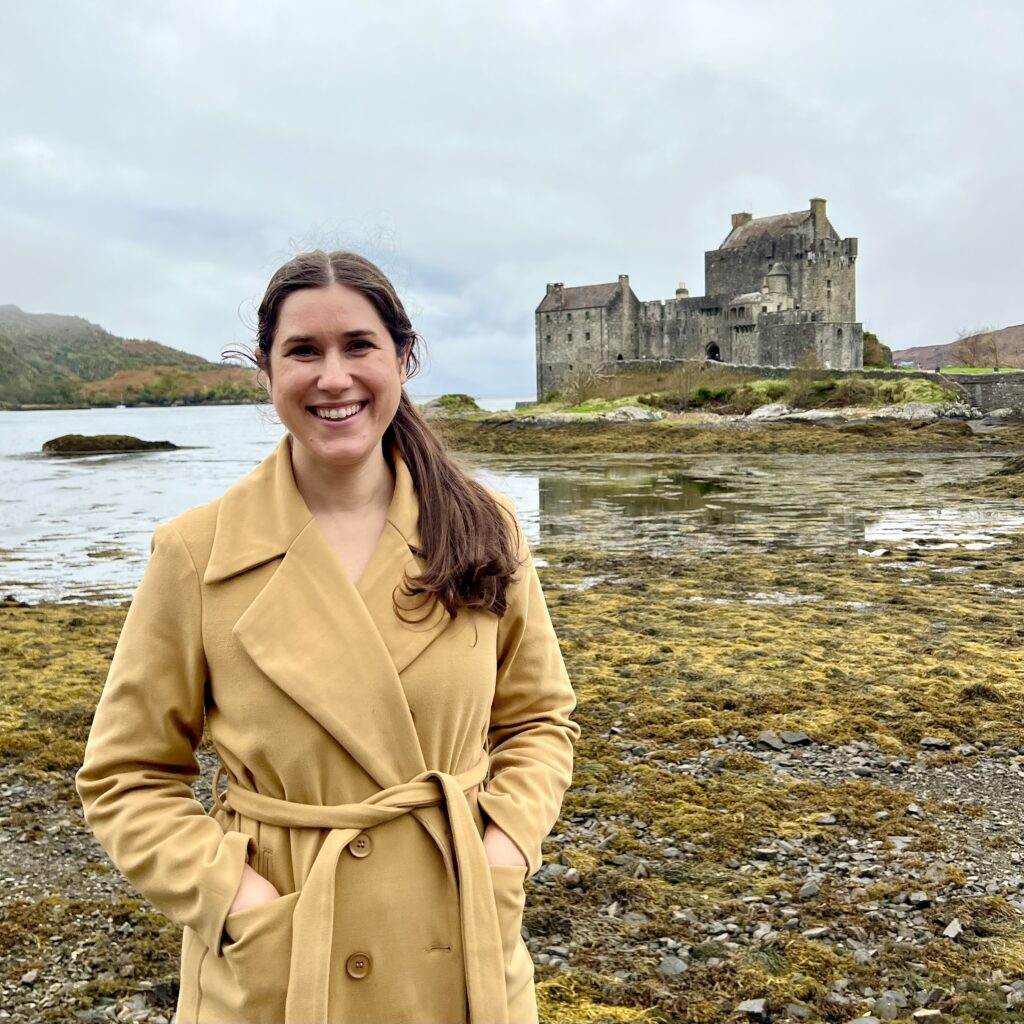 kate storm standing in front of eilean donan castle scotland
