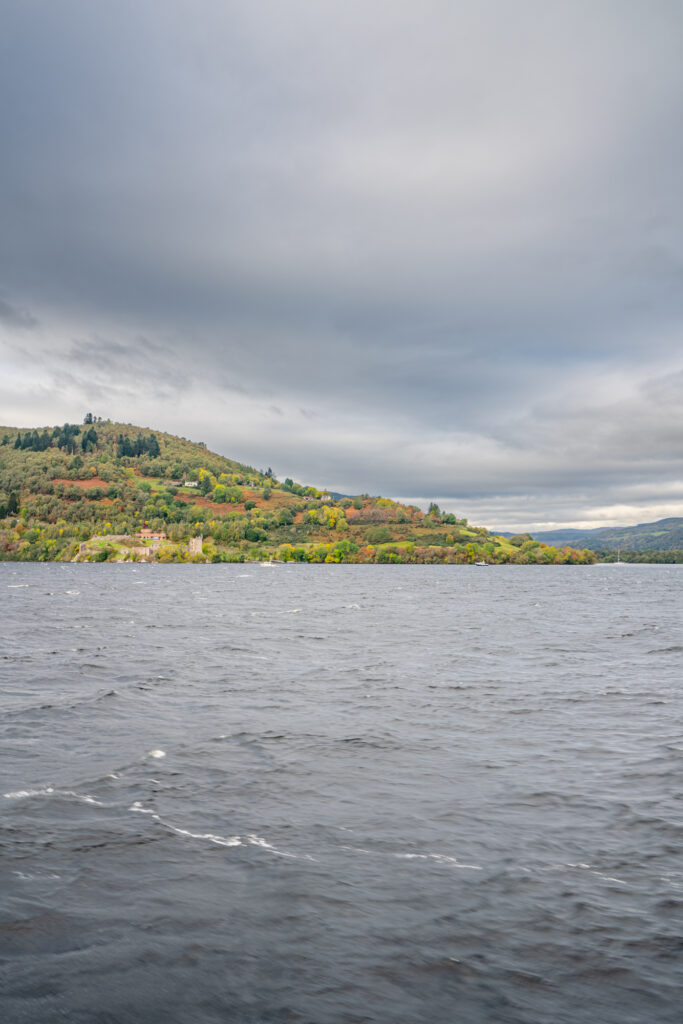 view of loch ness from loch ness cruise with urquhart castle in the distance