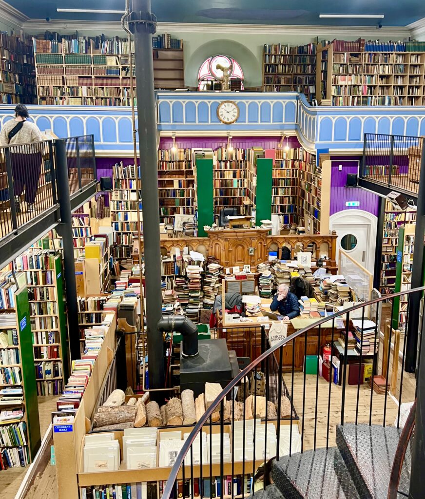 view of leakeys bookshop from second floor showing piece of spiral staircase and wooden stove
