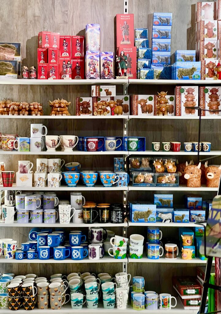 collection of mugs and other traditional scottish souvenirs from sale in one of many scotland gift shops