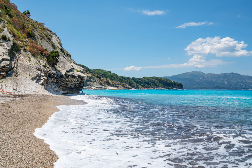 view of the bright blue water of mirror beach as seen from water's edge facing away from cliff