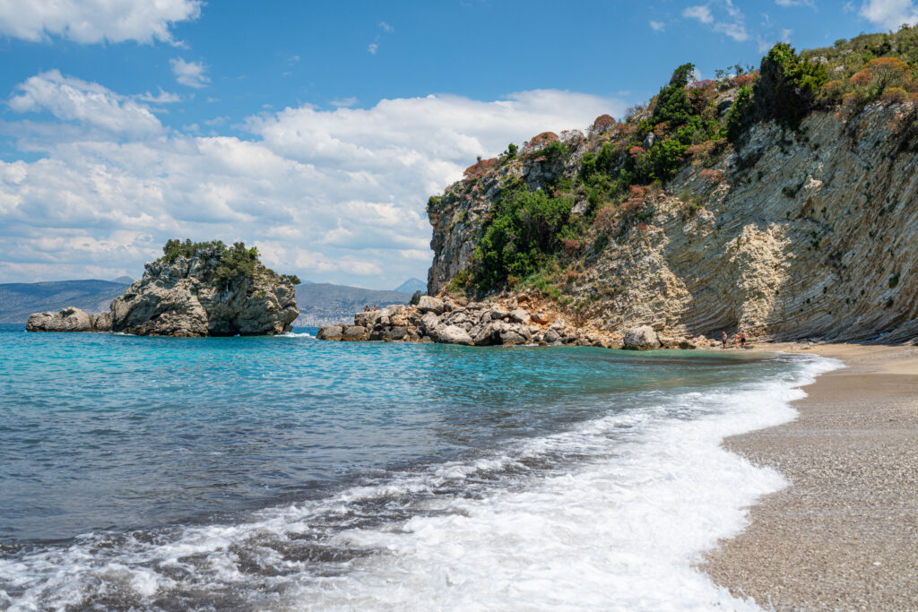 view of mirror beach as seen from water's edge facing the famous cliff