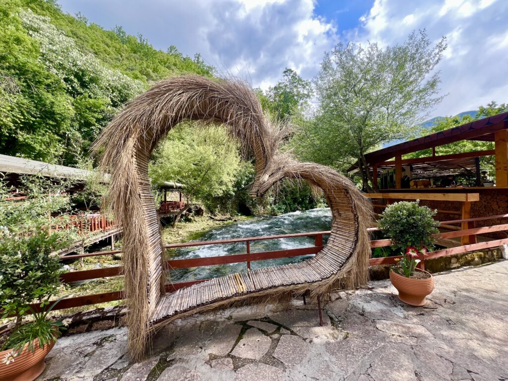 a wooden heart shaped bench built as a tourist photo spot at the blue eye albania
