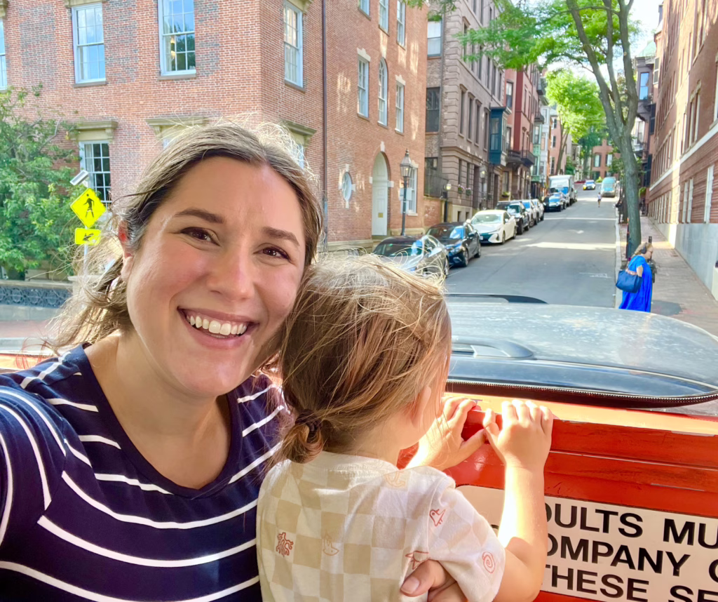 kate storm and her son taking a selfie on a boston duck tour, with beacon hill in the background