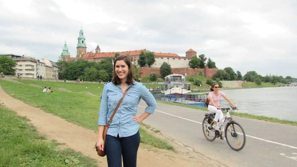 Kate Storm standing in front of Wawel Castle on the banks of the Vistula River when visiting Krakow Poland