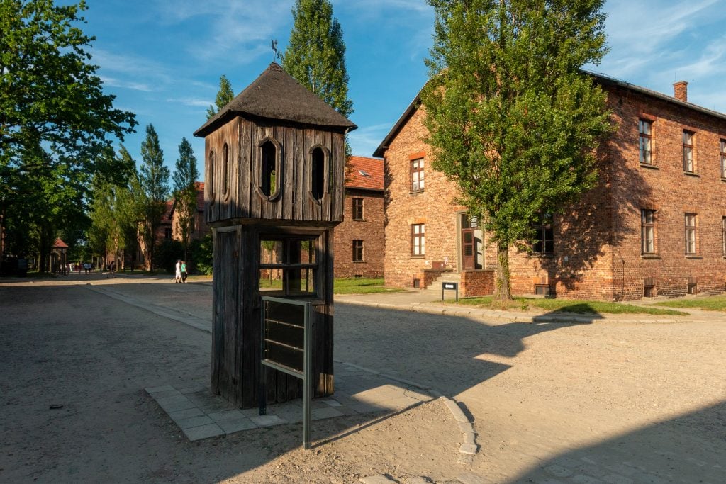 grounds as seen on an auschwitz tour with brick buildings in the background