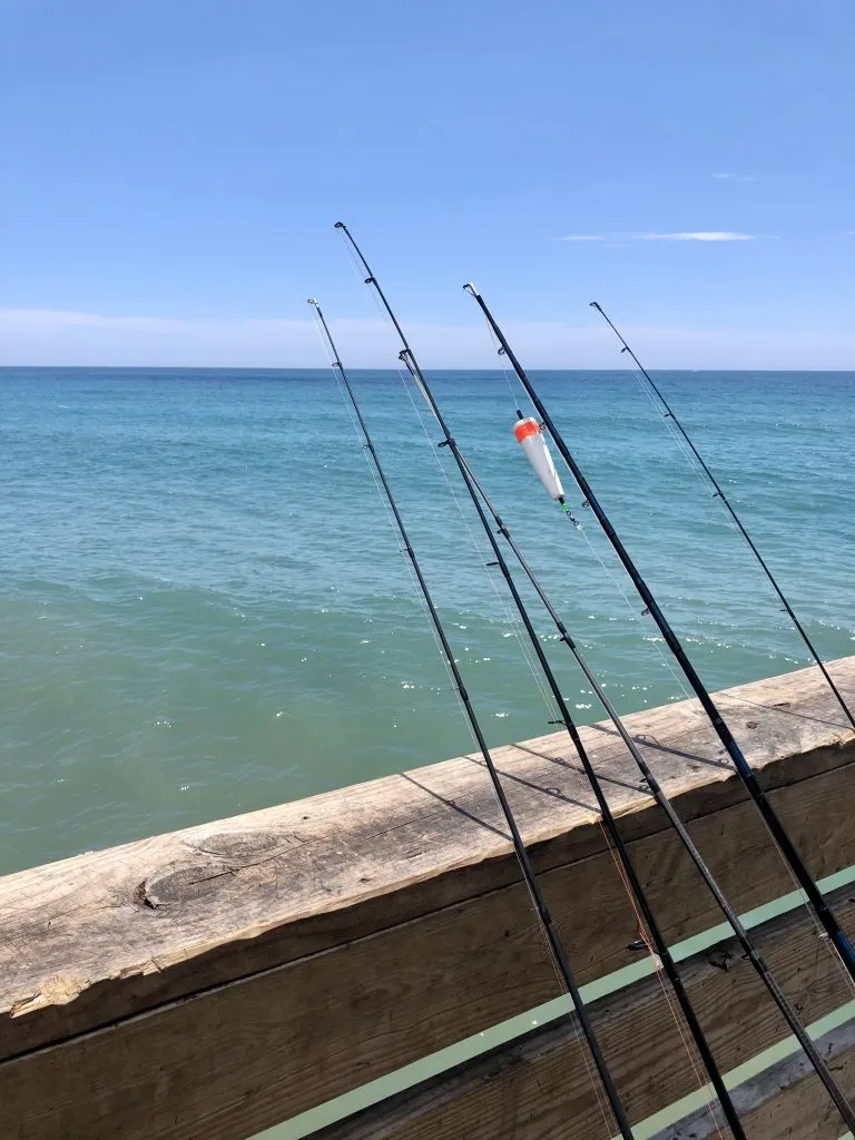 fishing poles leaning against oceanana pier, one of the best places to visit in atlantic beach north carolina