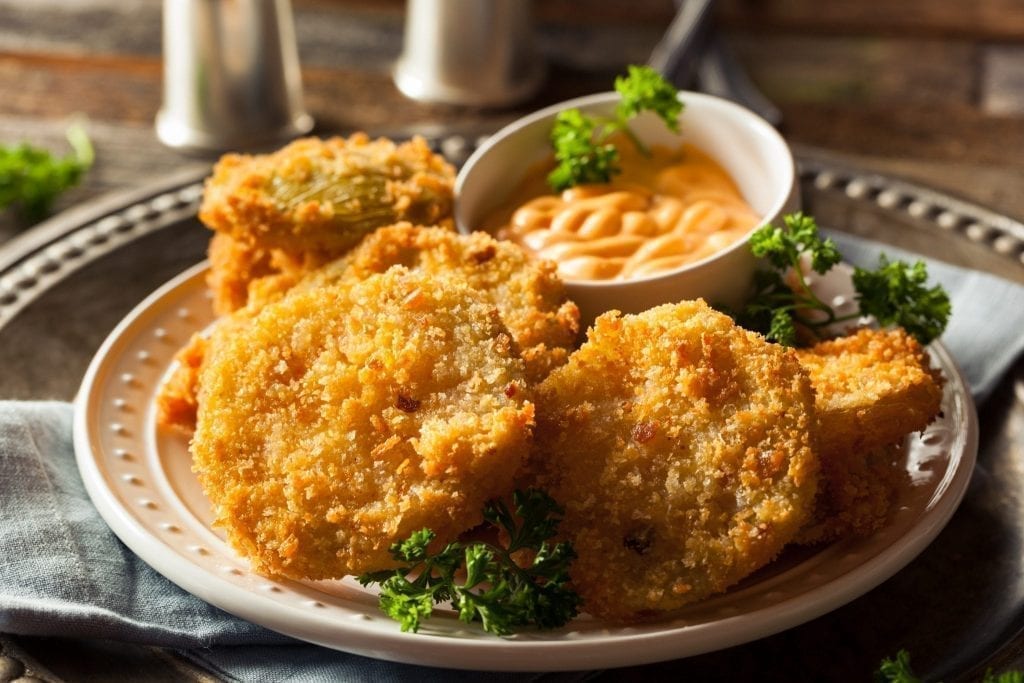 Round white plate with fried green tomatoes on it, one of the best Savannah foods to try