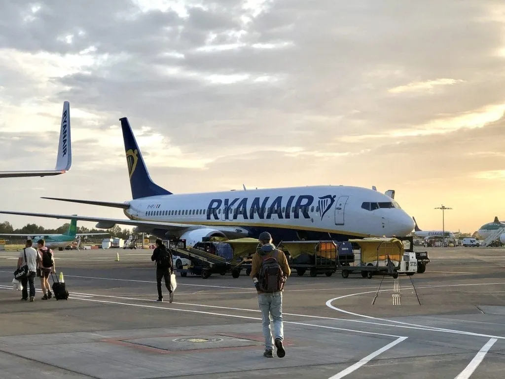 Ryanair plane parked on the tarmac with people boarding--you have to be extra careful to pack all your in flight essentials when taking a budget flight