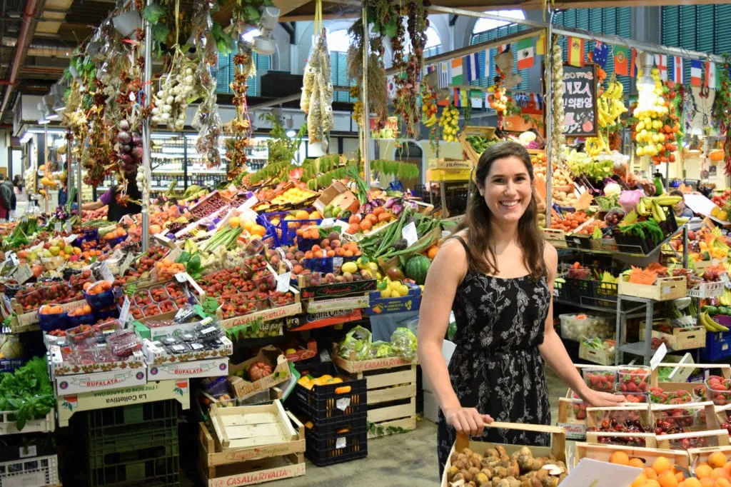 Kate Storm in a black sundress standing inside the Mercato Centrale, a must-see stop during your 2 day Florence itinerary