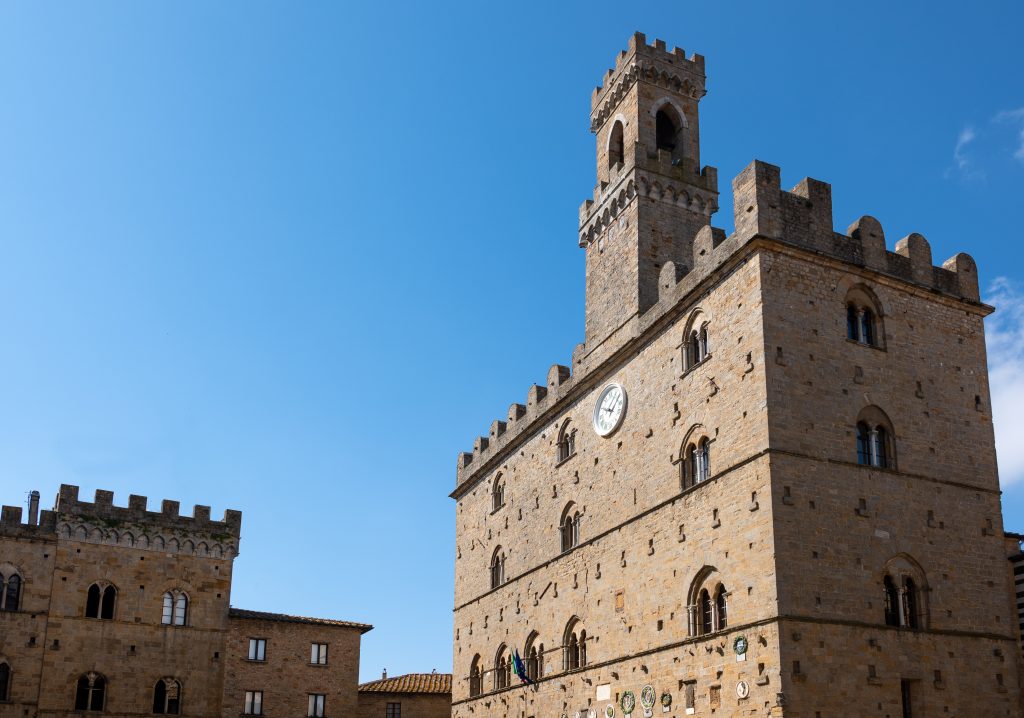 top of palazzo dei priori showing clock tower as seen from corner