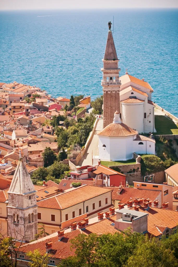 vertical photo of st georges church as seen from piran town walls