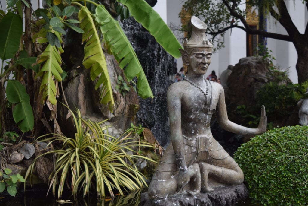 small statue of buddha in bangkok thailand at a wat, a modest addition to our trip to thailand cost