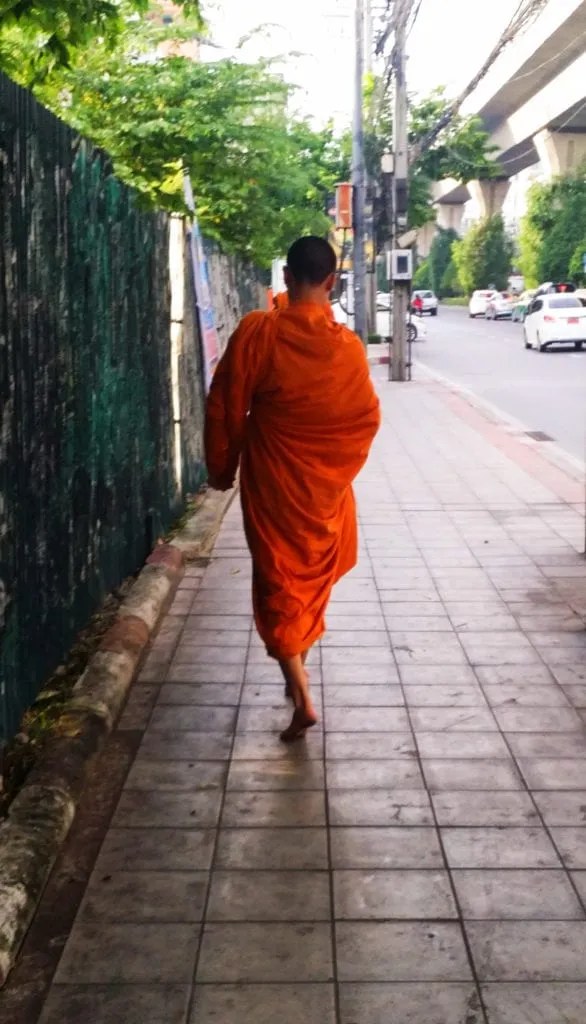 young monk in an orange robe that we saw walking down the street our first time in bangkok thailand