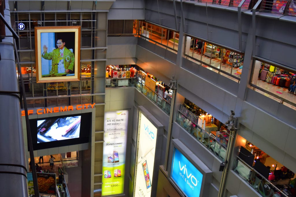 mbk shopping mall bangkok with portrait of king of thailand in it. one of our bangkok travel tips is to cool off at the malls