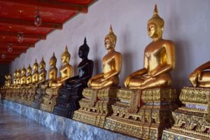 collection of gold buddha statues at a wat, a modest addition to our trip to thailand cost