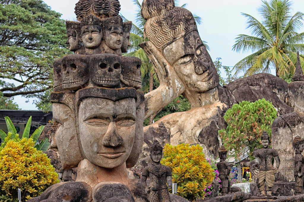 religious statues including a reclining buddha in buddha park, one of the best things to do in vientiane laos