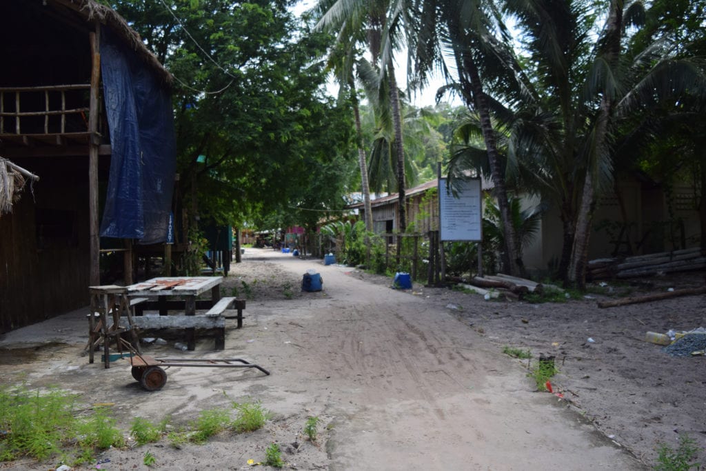 dirt road leading through a village in koh rong cambodia