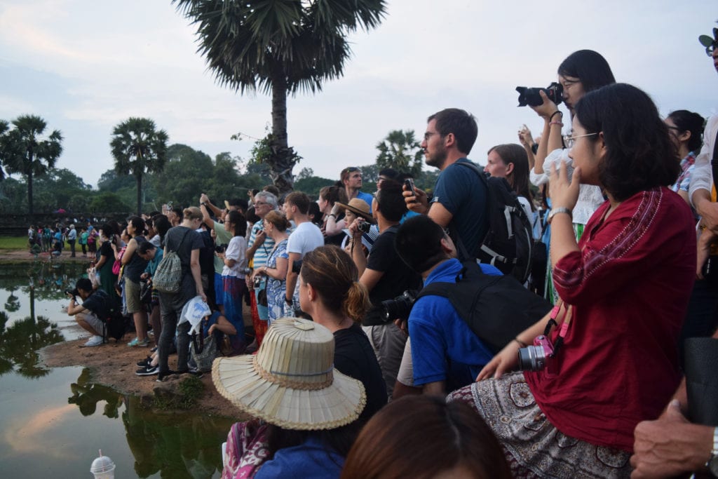 large crowd of tourists with cameras at angkor wat sunrise