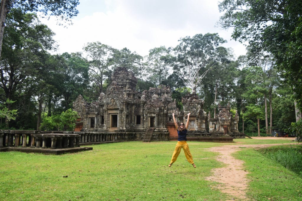 kate storm jumping in front of a temple when visiting angkor wat tips