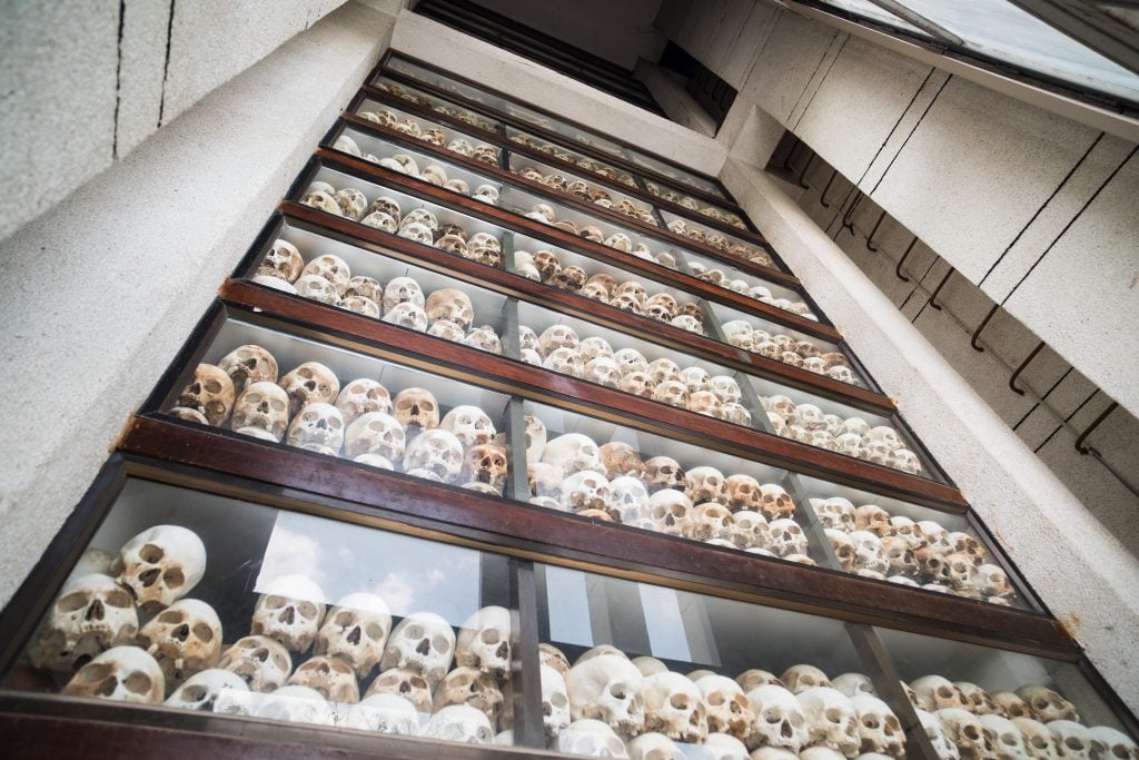 collection of human skulls displayed in memorial building honoring victims of khmer rouge killing fields museum