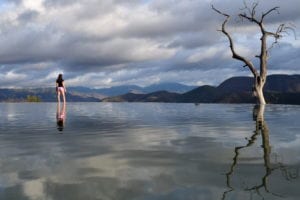 kate storm standing on the edge of a pool at hierve el agua, one of the most fun things to do in oaxaca mexico