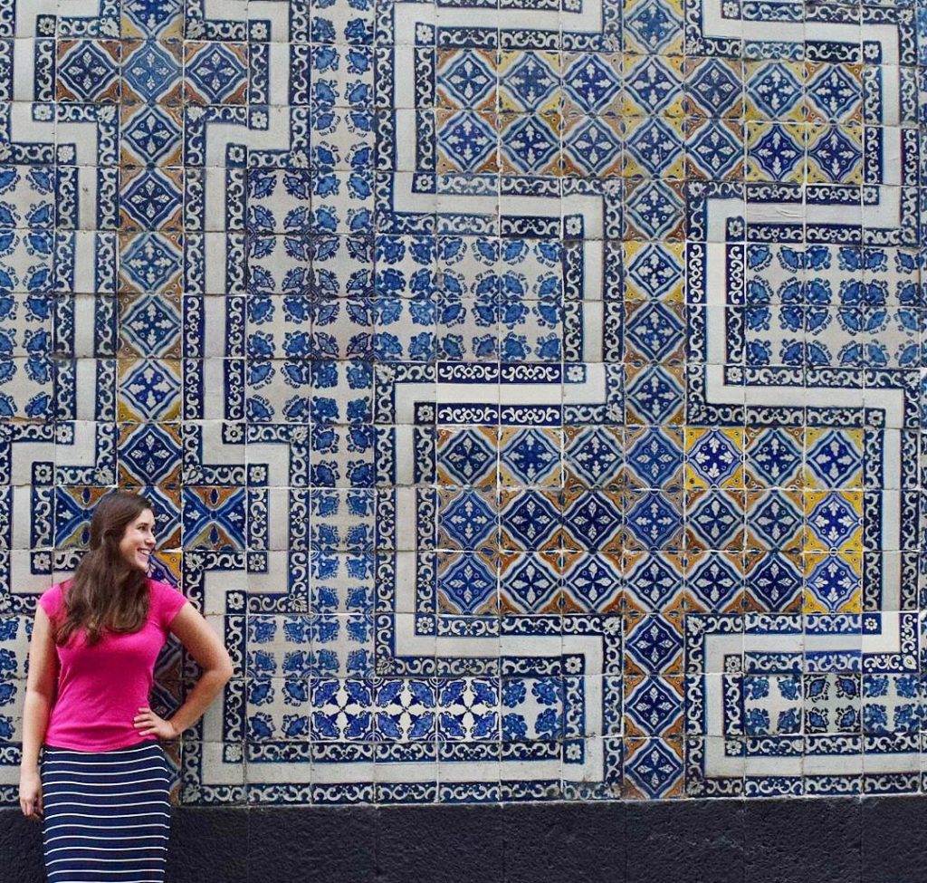 kate storm in a pink shirt standing in front of the house of tiles during a mexico city itinerary