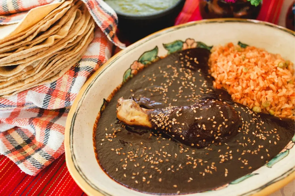 plate of mole with tortillas in the background, eating mole is one of the best things to do in oaxaca mexico