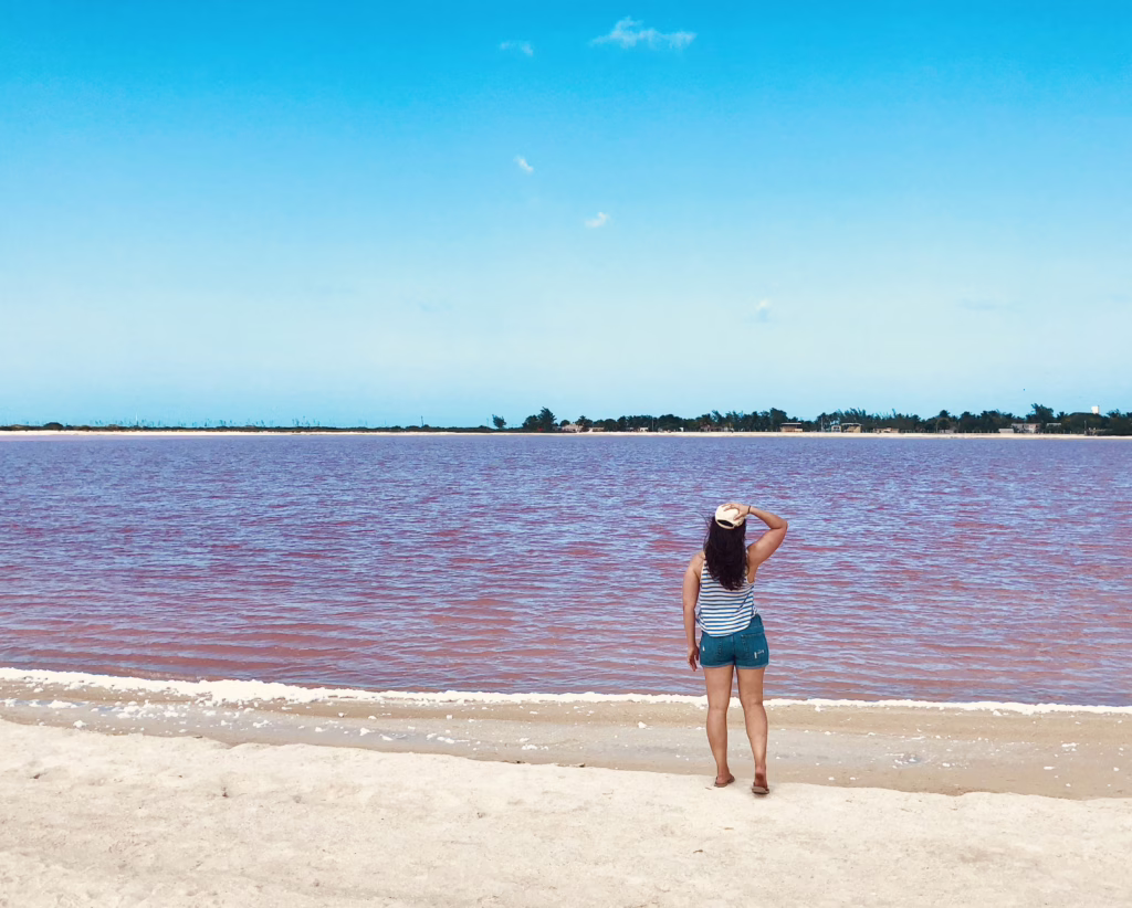 kate storm facing away from the camera and looking at a pink lagoon mexico