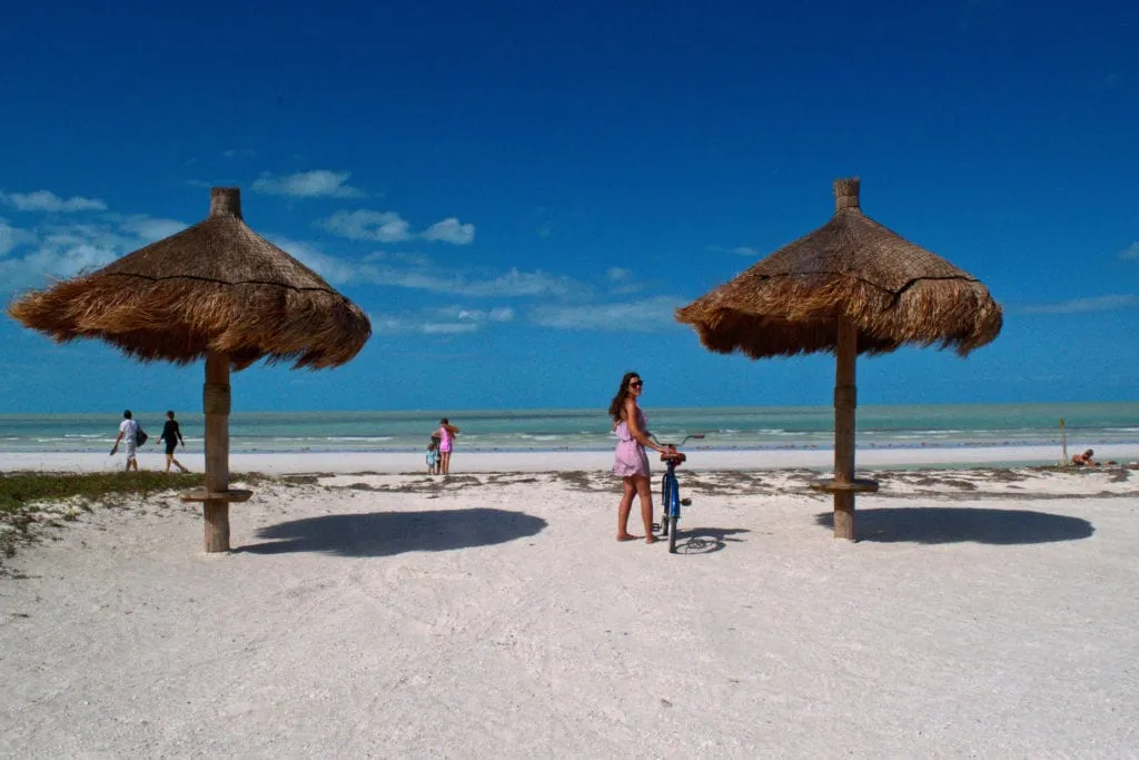 Kate storm standing with a bike on the beach on isla holbox mexico things to do