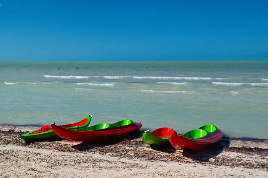4 kayaks on the edge of the water on a sunny day