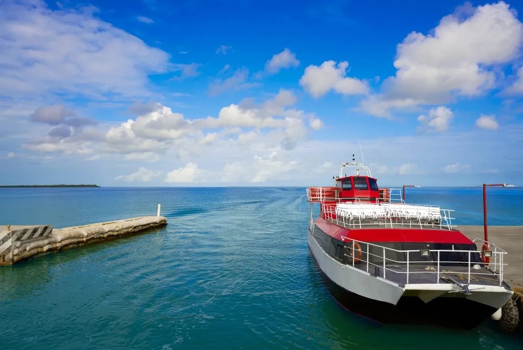 chiquila port with a red and white ferry parked on the water