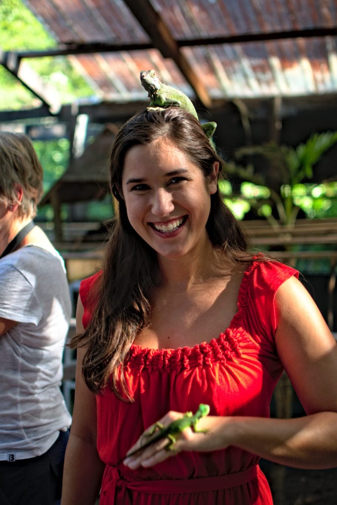 kate storm posing with two green iguanas at the green iguana project, one of the best things to do in belize