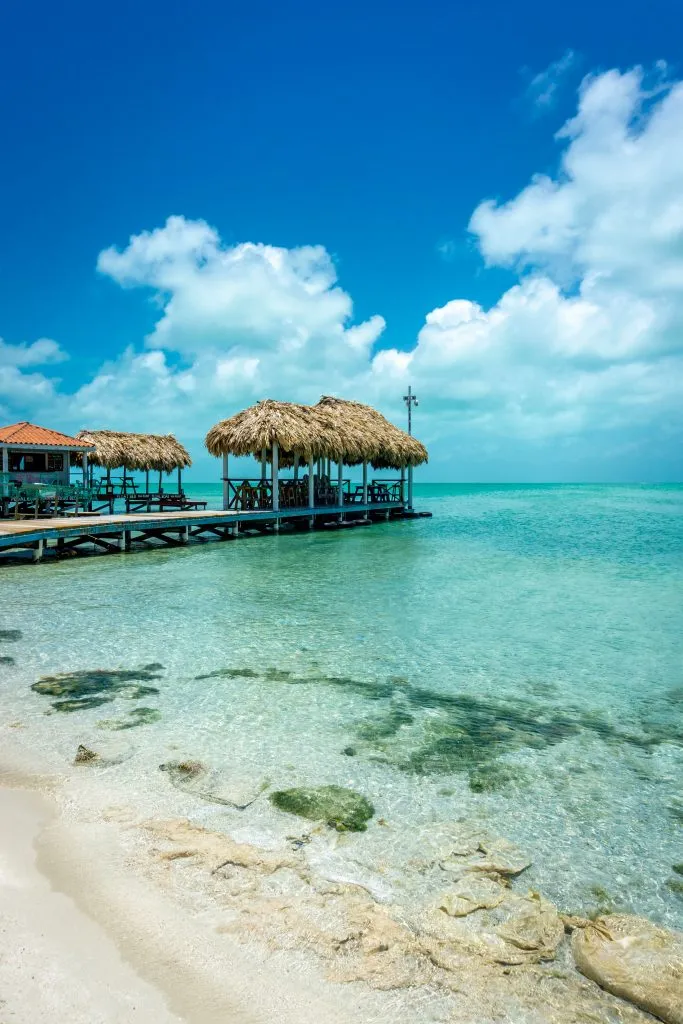 view of beach huts over the water on ambergis caye belize things to do