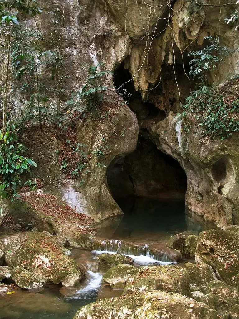 entrance to the atm cave bucket list belize experience with small waterfalls in the river