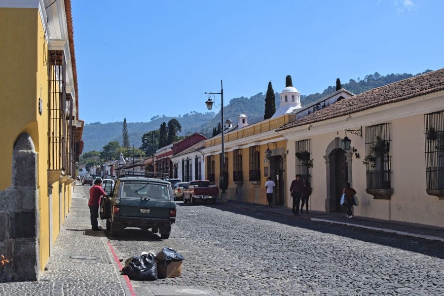 colorful street in antigua guatemala with a car on it, as seen during a 2 week guatemala itinerary