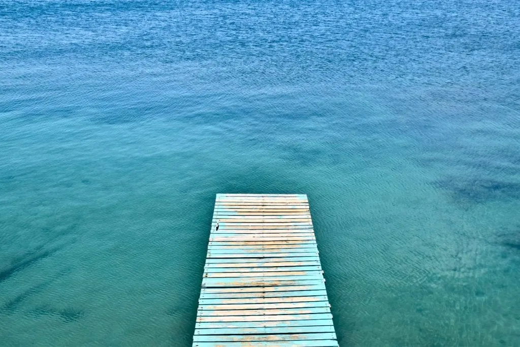 view of a dock over the water in utila honduras as seen from above. views like this don't add to the bottom line of a trip to honduras budget