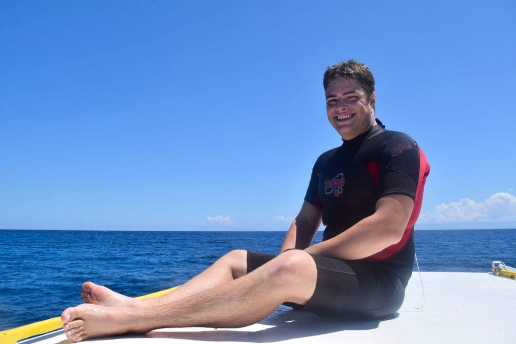 jeremy storm on a dive boat wearing a wet suit in utila honduras