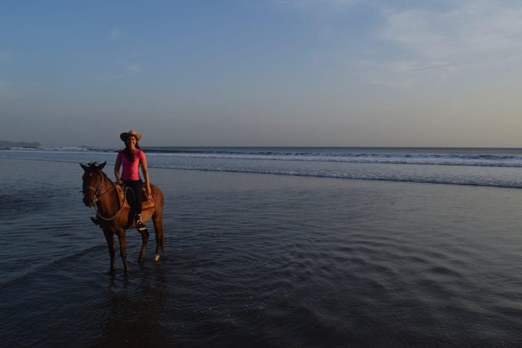 nicaragua horseback riders at sunset on a beach