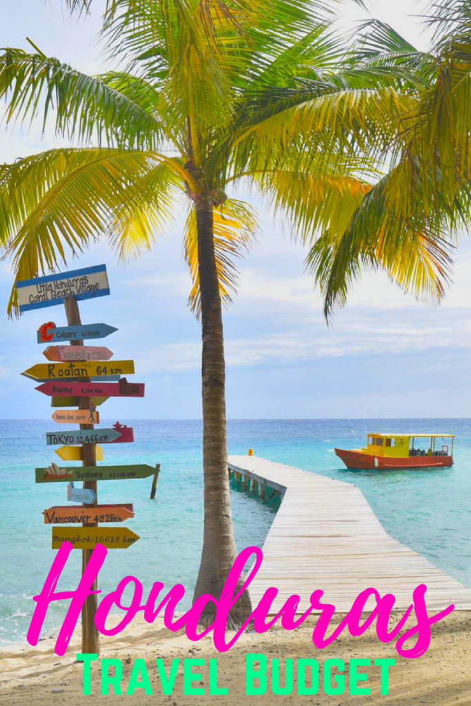 photo of dock with colorful sign and palm tree in utila, pink and green text reads "honduras travel budget" at the bottom of the image