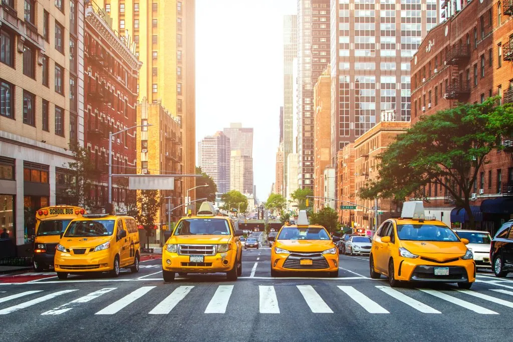 four taxis stopped at an intersection in manhattan, a common sight during a 2 day weekend in new york city