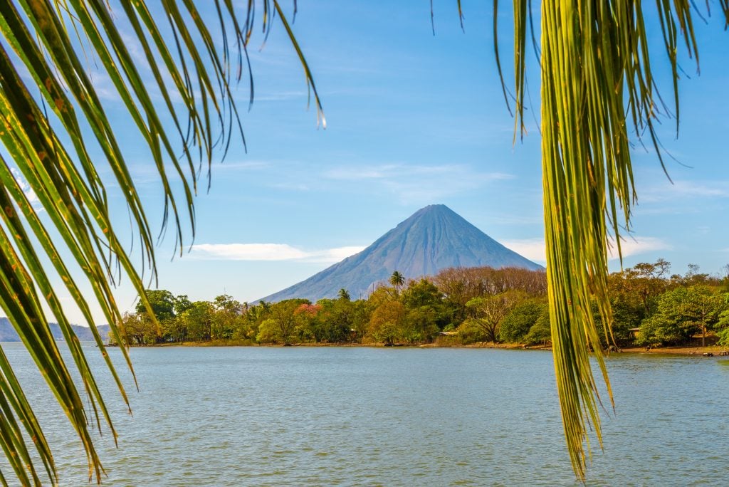 volcano concepcion in ometepe nicaragua as seen through palm leaves