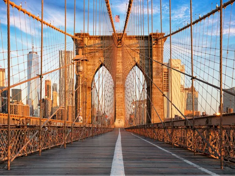 view on the brooklyn bridge facing manhattan on a sunny morning, one of the top attractions on a 2 day weekend in new york itinerary