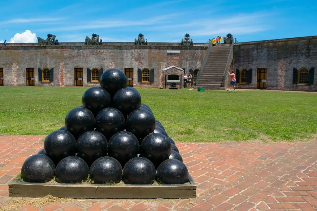 Inner courtyard of Fort Macon NC with a stack of cannonballs built into a pyramid in the foreground