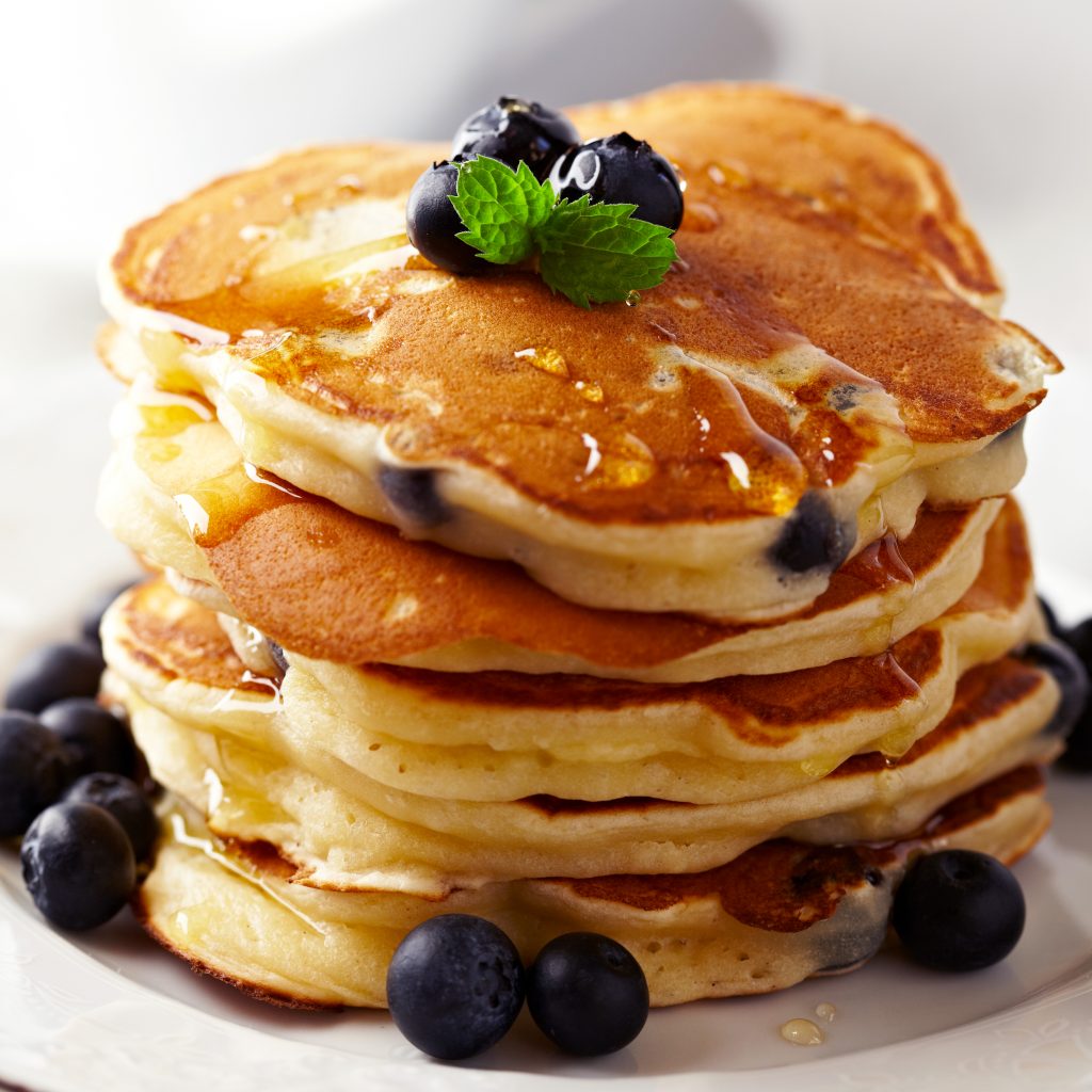 stack of blueberry pancakes on a white plate