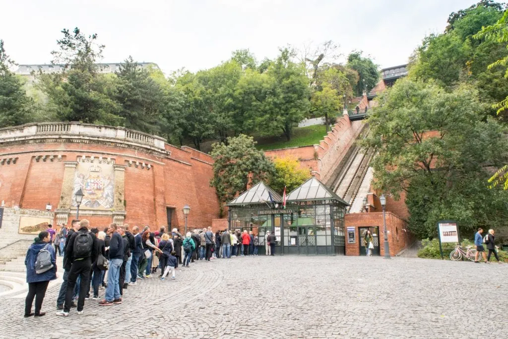 view of people waiting in line for the castle hill funicular, one of the top things to do budapest hungary
