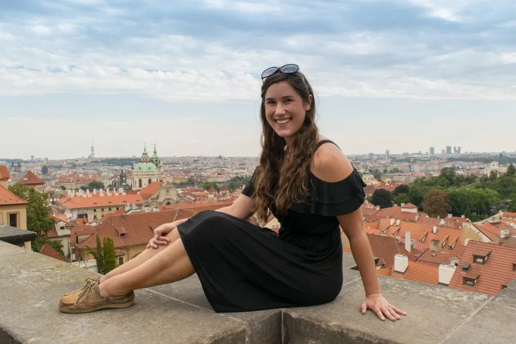 Kate Storm ngồi trên một mỏm đá nhìn ra khung cảnh miễn phí của đường chân trời Praha khi đi du lịch Praha tiết kiệm Kate Storm ngồi trên một mỏm đá nhìn ra khung cảnh miễn phí của đường chân trời Praha khi đi du lịch Praha tiết kiệm