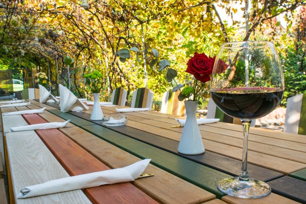 glass of red wine sitting on an outdoor dining table, as seen when visiting bucharest attractions