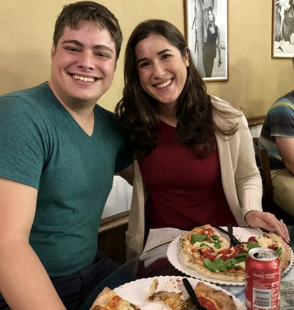 Kate Storm and Jeremy Storm at Gusta Pizza in Florence with sliced pizza in front of them. Gusta Pizza serves the best pizza in Florence Italy