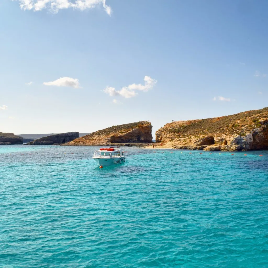 small boat in otherwise empty blue lagoon malta